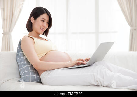 Schwangere Frauen mit Notebook-computer Stockfoto