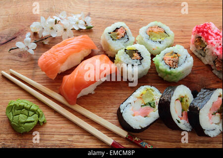 Mischung aus Sushi-Rollen mit hölzernen Stäbchen Stockfoto