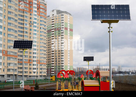 Ein Kinderspielplatz im Hof eines Mehrfamilienhauses mit Sonnenkollektoren Stockfoto