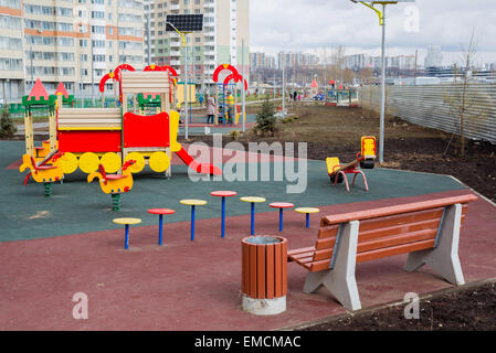 Ein Kinderspielplatz im Hof eines Mehrfamilienhauses mit Sonnenkollektoren Stockfoto
