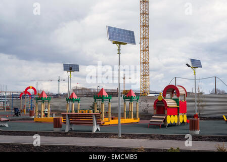 Ein Kinderspielplatz im Hof eines Mehrfamilienhauses mit Sonnenkollektoren Stockfoto