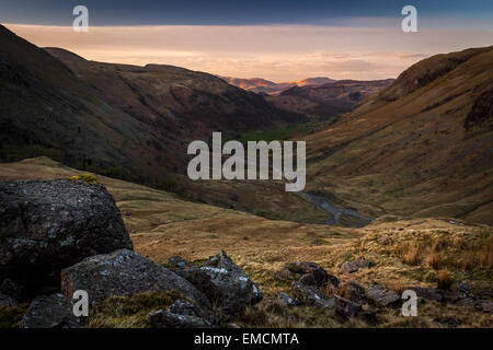 Blick von Seathwaite fiel wie die Sonne untergeht über Skiddaw und Blencathra in der Ferne Stockfoto