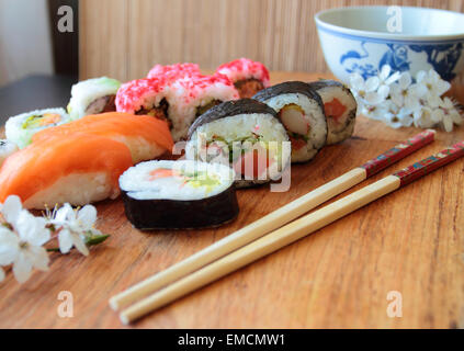 Mischung aus Sushi-Rollen mit hölzernen Stäbchen Stockfoto