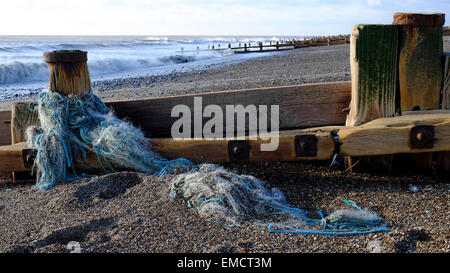 Ausrangierte oder verlorene Fischernetze gewickelt auf einer Buhne auf Worthing Strand erwischt Stockfoto