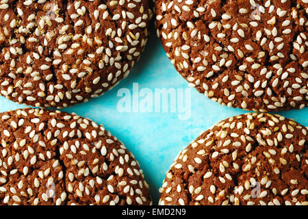 Essen-Hintergrund mit Cookie Stücken mit Sesam auf beiden Hälften auf blauem Hintergrund geknackt. Makroaufnahme. Platz für Text. Stockfoto