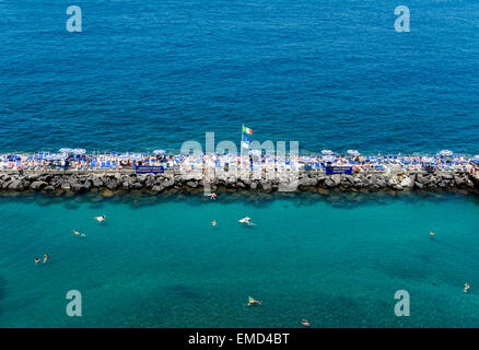 Schwimmer und Sonnenanbeter genießen die Einrichtungen und die sichere, seichtes Wasser in einer Strandbar / club in Sorrento, Italien. Stockfoto