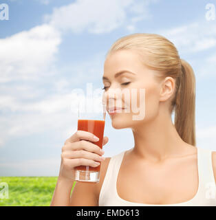 junge Frau trinkt Tomatensaft Stockfoto