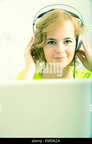 Eine junge plus Größe Frau wiedergeben von Audio vor einem Laptopcomputer. Stockfoto