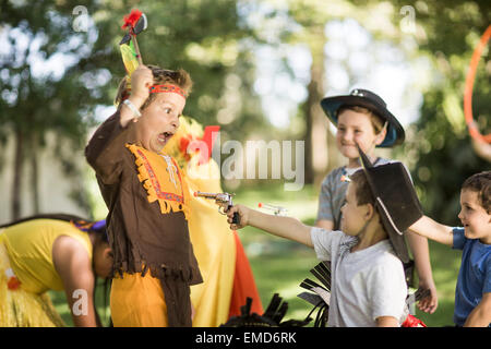 Kinder im Garten spielen, Cowboys und Indianer Stockfoto