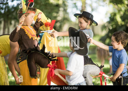 Kinder im Garten spielen, Cowboys und Indianer Stockfoto