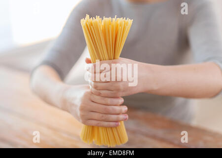 Nahaufnahme von weiblichen Händen mit Spaghetti Nudeln Stockfoto