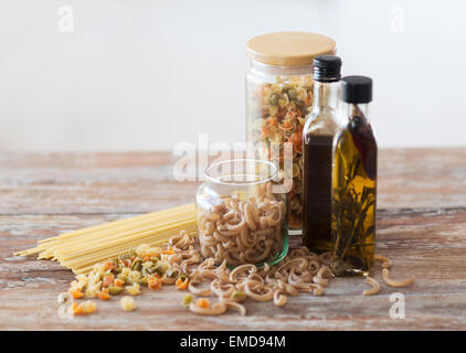 Nahaufnahme von zwei Flaschen Olivenöl und Nudeln in Glas Stockfoto