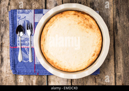 Frisch gebackenen Käsekuchen auf Holztisch. Dessert Kochen Rezept Hintergrund. Top View-Bild Stockfoto