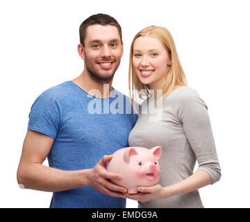 lächelnde paar halten große Sparschwein Stockfoto