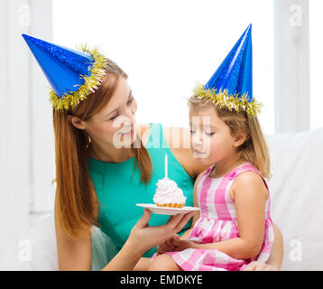 Mutter und Tochter in blauen Hüte mit Kuchen Stockfoto