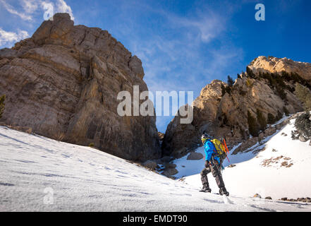 Bergsteiger vor einer hohen Felswand. Stockfoto