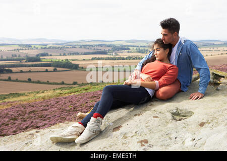 Junges Paar sitzt auf Felsen Panorama Stockfoto