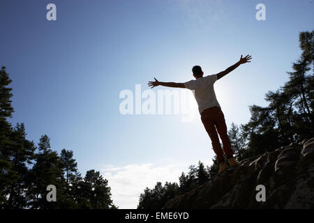Silhouette der Jüngling auf Felsen Stockfoto