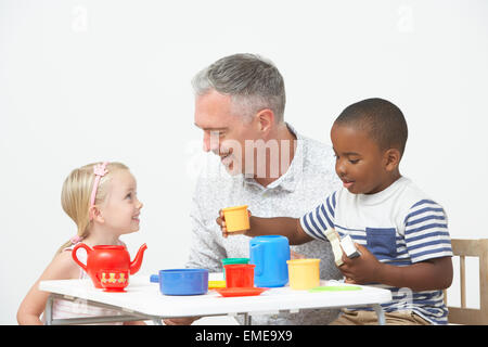 Vorschulalter Kinder freuen sich über Tee-Party mit Lehrer Stockfoto