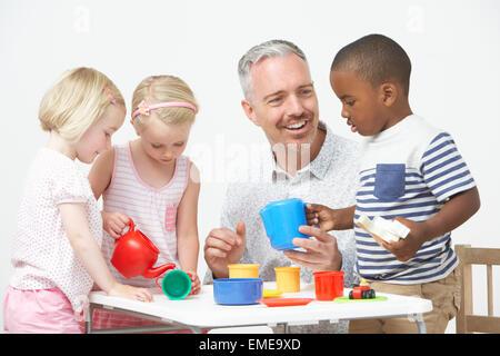 Vorschulalter Kinder freuen sich über Tee-Party mit Lehrer Stockfoto