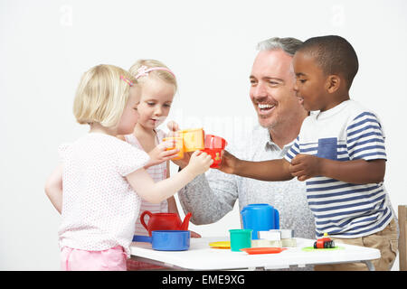 Vorschulalter Kinder freuen sich über Tee-Party mit Lehrer Stockfoto