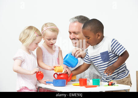 Vorschulalter Kinder freuen sich über Tee-Party mit Lehrer Stockfoto