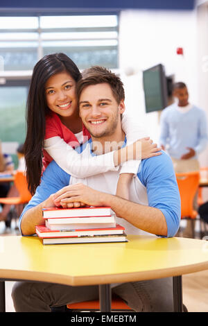 Männliche und weibliche Studenten im Klassenzimmer mit Büchern Stockfoto