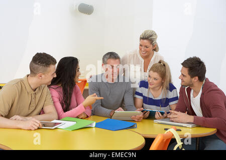 College-Studenten mit Tutor mit digitalen Geräten Stockfoto