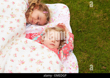 Zwei Mädchen liegen unter Decke auf Campingurlaub Stockfoto