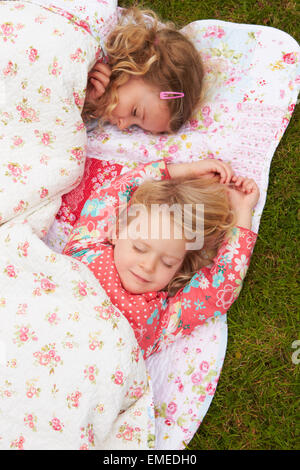 Zwei Mädchen liegen unter Decke auf Campingurlaub Stockfoto