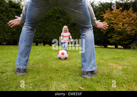 Vater und Tochter zusammen Fußballspielen im Garten Stockfoto