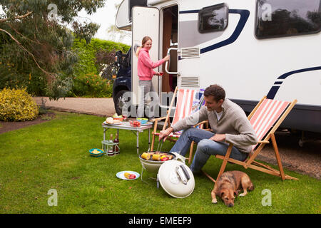 Paar In Van Barbeque auf Camping-Urlaub genießen Stockfoto