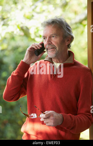 Reifen Sie Mann mit schnurlosen Telefon zu Hause Stockfoto