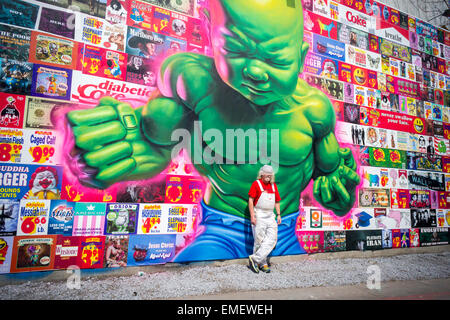 Renommierte Straßenkünstler Ron English posiert vor seinem neuen Bowery Wandbild in Soho in New York Samstag, 18. April 2015. Englisch Arbeit parodiert und kritisiert Konsumismus und es ist sein erstes öffentliches Werk in mehr als einem Jahr. Der rekonstruierte Raum, kuratiert von Jeffrey Deitch, ist berühmt für Hosting-Wandbilder von Graffiti-Künstlern, vor allem Keith Haring. (© Richard B. Levine) Stockfoto