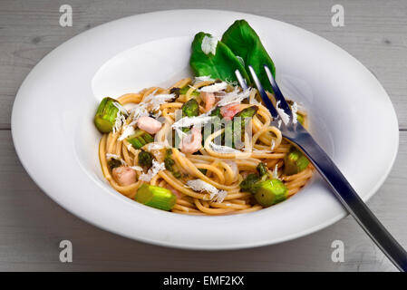 Vollkorn-Nudeln mit grünem Spargel, Shrimps, Pesto Bärlauch (Stoffen), gehobeltem Parmesan und Basilikum Blätter. Stockfoto