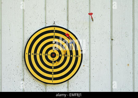 Finnische Dartscheibe und Darts auf eine weiße Tafel-Wand Stockfoto