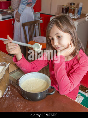 junges Mädchen Wuchsverhalten beim cooking - Gebotes Stockfoto