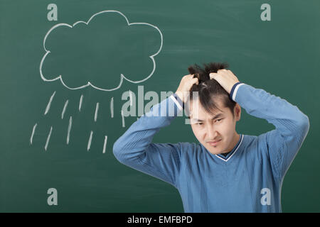 Ein Kerl mit einer schlechten Stimmung, gezeichnet auf einer Cloud von Blackboard und Regen Stockfoto