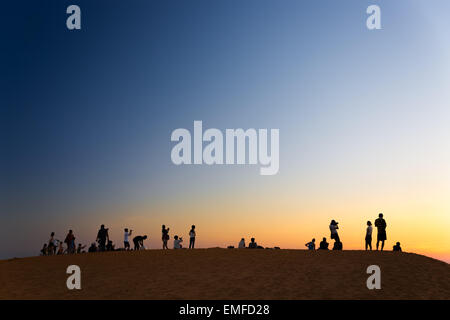 MUI NE, VIETNAM - 8. Februar 2014: Touristen beobachten Sonnenuntergang am roten Sanddünen in der Nähe von South China Sea Stockfoto