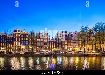 Historische Häuser Amsterdam Singel 396-366 in der Nacht. Amsterdam Canal beherbergt malerische Aussicht bei Sonnenuntergang. Stockfoto