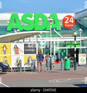 Shopper am Haupteingang zu Asda Food & George Kleidung Supermarkt Shopping Einzelhandel Geschäft mit 24 Stunden Schild Colchester Essex England Stockfoto