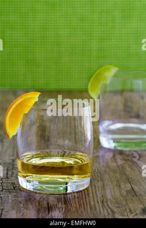 Hochwertigen Tequila in einem Cognac-Schwenker mit orange garnieren und Silber Tequila in der Hintergrund jedoch unscharf Stockfoto