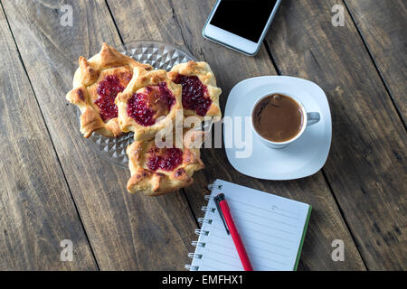 hausgemachte Blätterteig gefüllt mit Erdbeer-Marmelade und Kaffee Stockfoto