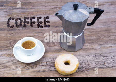 Espresso mit einem glasierten Donut auf einem Holztisch von oben mit Text in Kaffeebohnen Kaffee Stockfoto