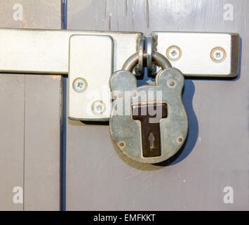 Vorhängeschloss auf Grunge grau Tür gesperrt Stockfoto