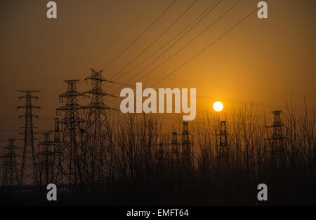 Silhouetten von Strommasten und Linien während Sonnenuntergang china Stockfoto