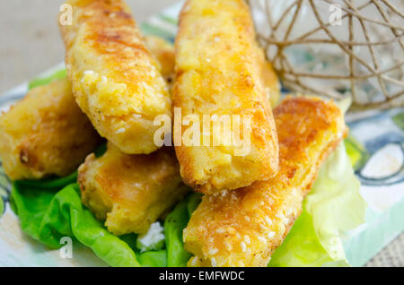 Nach Hause gebackenes Sesam Kuchen auf ein Schneidebrett dekoriert mit grünem Salat Stockfoto