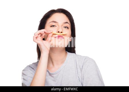 natürliche ausdrucksstarken Frau spielt mit Pommes frites, vor Junk-e- und gesund essen, isoliert auf weiss Stockfoto