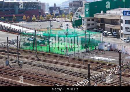 HIROSHIMA, JAPAN - ca. APRIL 2013: Kleine Baseball-Feld mit spielenden Kindern ist in der Nähe der Eisenbahn in Provinzstadt in Hiro Stockfoto