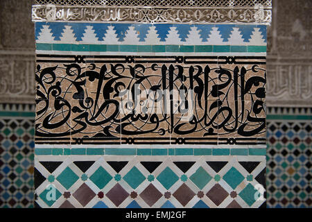 Al Attarine Madrasa, Koranschule, in Fes, Marokko.  Detail von arabischer Schrift geschnitzt in Fliese, höchste Form der Kunst in Koranschulen Stockfoto